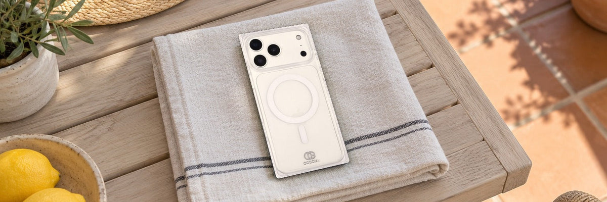 COCOMII Crystal Clear MagSafe rectangle case on a linen towel on a sunlit terrace table beside a straw hat