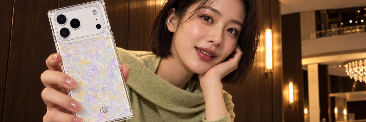 Woman in a pistachio cashmere knit on an opera foyer bench scrolling with a COCOMII opal finish case in Aurora