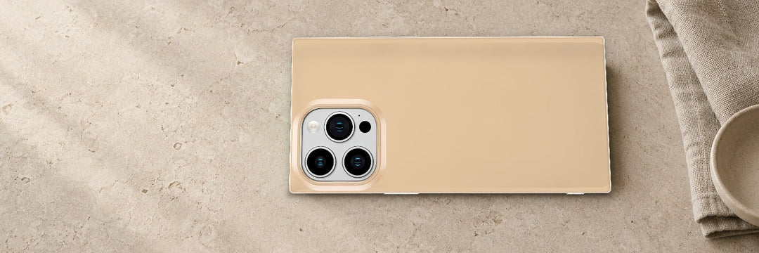 COCOMII Glossy Nude Solid rectangle case lying flat on a beige stone surface beside a linen cloth and a ceramic bowl