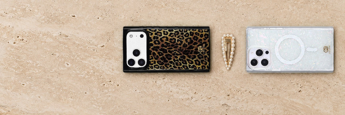 COCOMII Leopard and Opal Pearlescent rectangle cases lying flat side by side on cream travertine with a pearl hair clip between them