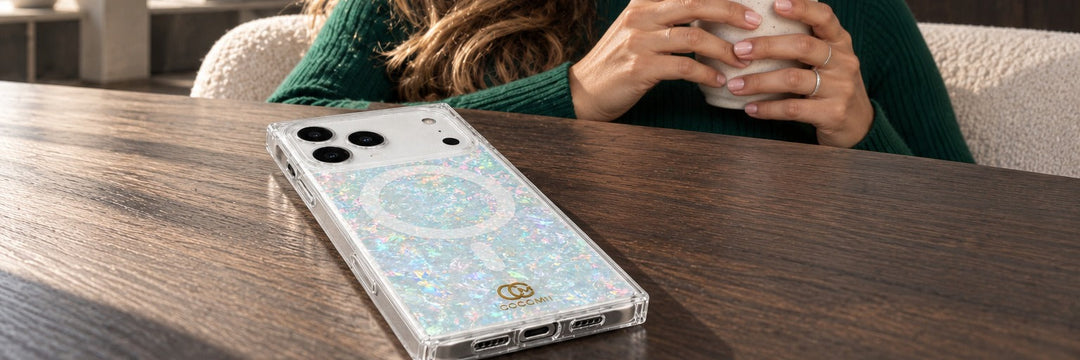 Woman in an emerald turtleneck in a concrete apartment sitting back with a COCOMII opal finish case in Pearlescent